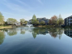 Stormwater pond with fountain surrounded by apartment buildings maintained by Triangle Pond Management.